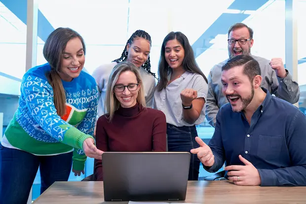 Group of people all smiling and happy in the office.